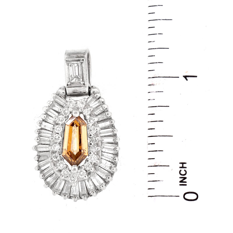 Vintage Approx. 1.35 Carat Fancy Yellow Brown Diamond and 18 Karat White Gold Pendant accented throughout with Baguette and Round Brilliant Cut Diamonds.