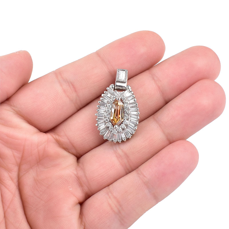 Vintage Approx. 1.35 Carat Fancy Yellow Brown Diamond and 18 Karat White Gold Pendant accented throughout with Baguette and Round Brilliant Cut Diamonds.