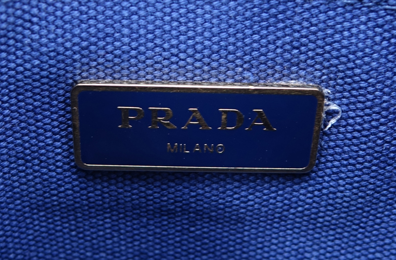 Prada Blue Canvas Denim Tote PM. Gold tone hardware. Interior of canvas with one zippered pocket and a slot pocket.