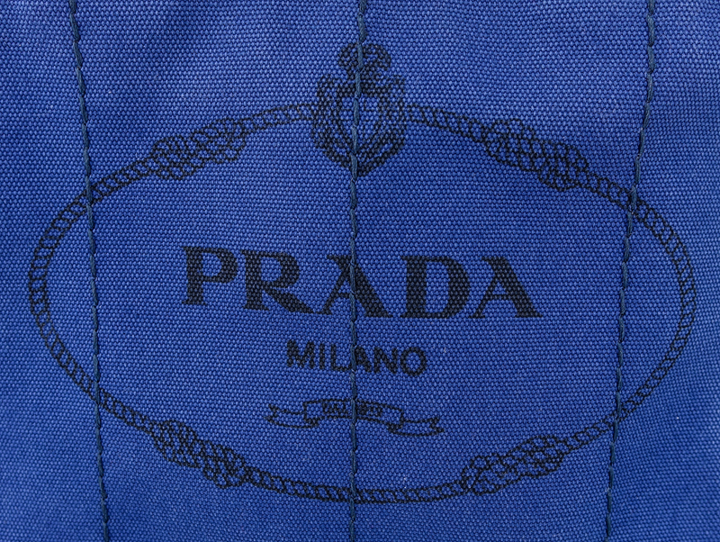 Prada Blue Canvas Denim Tote PM. Gold tone hardware. Interior of canvas with one zippered pocket and a slot pocket.