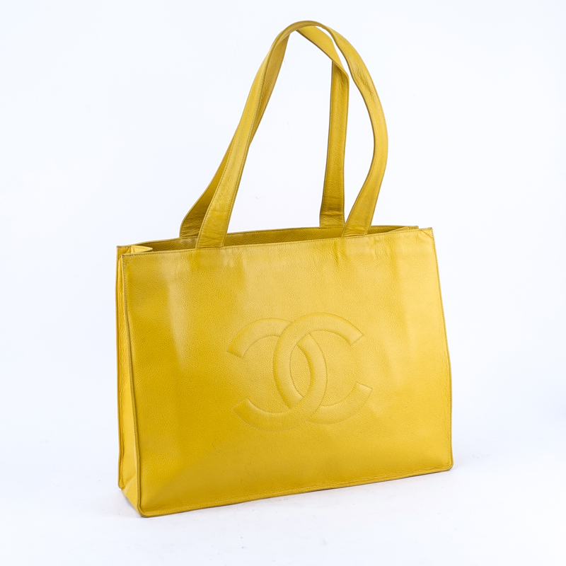 Chanel Yellow Caviar Leather Vintage Tote With Front Logo. Gold tone hardware. Interior with large zipper pocket.