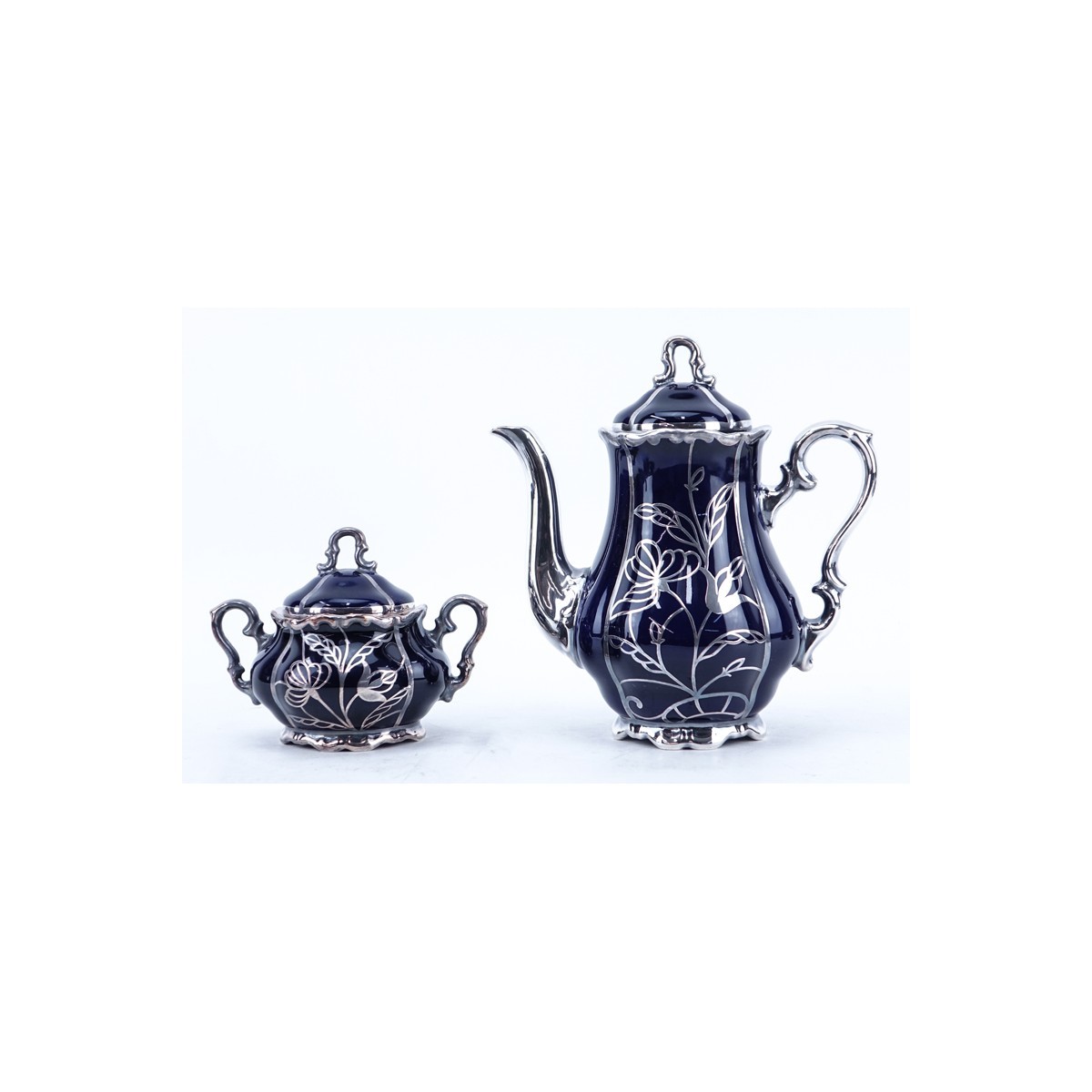 Thirteen (13) Piece German Cobalt Blue Porcelain and Pure Silver Tea Set. Includes: five cups, four saucers, creamer, covered sugar, vase, and tea pot.