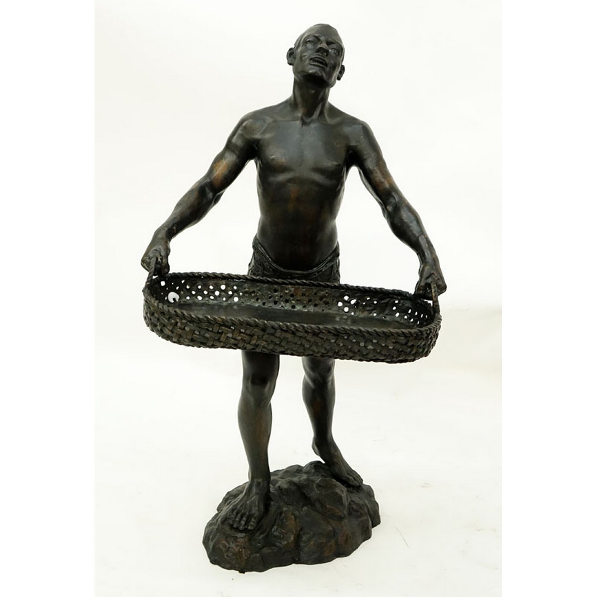 A Patinated Bronze Sculpture, Nubian Male Carrying Basket, Unsigned. Rubbing to surface overall good condition.