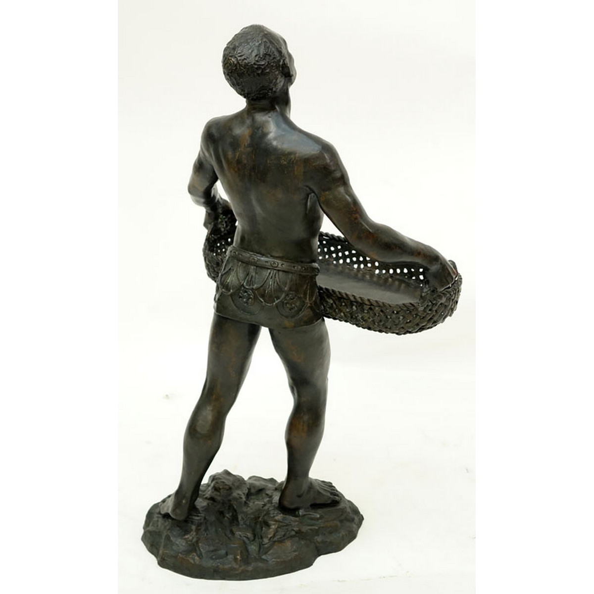 A Patinated Bronze Sculpture, Nubian Male Carrying Basket, Unsigned. Rubbing to surface overall good condition.