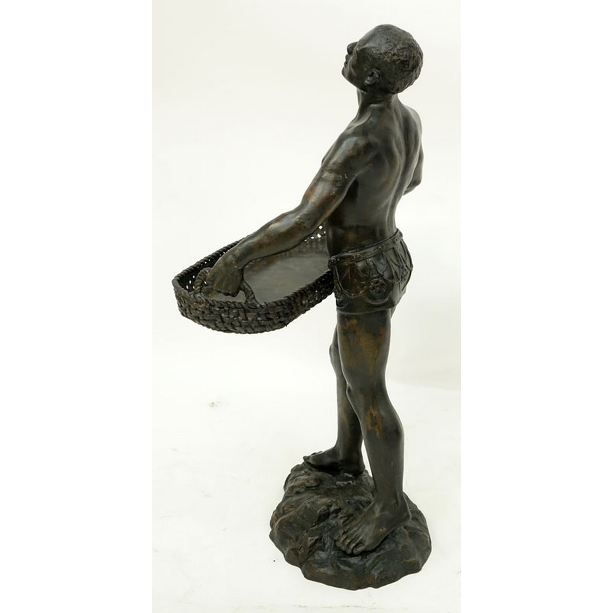 A Patinated Bronze Sculpture, Nubian Male Carrying Basket, Unsigned. Rubbing to surface overall good condition.