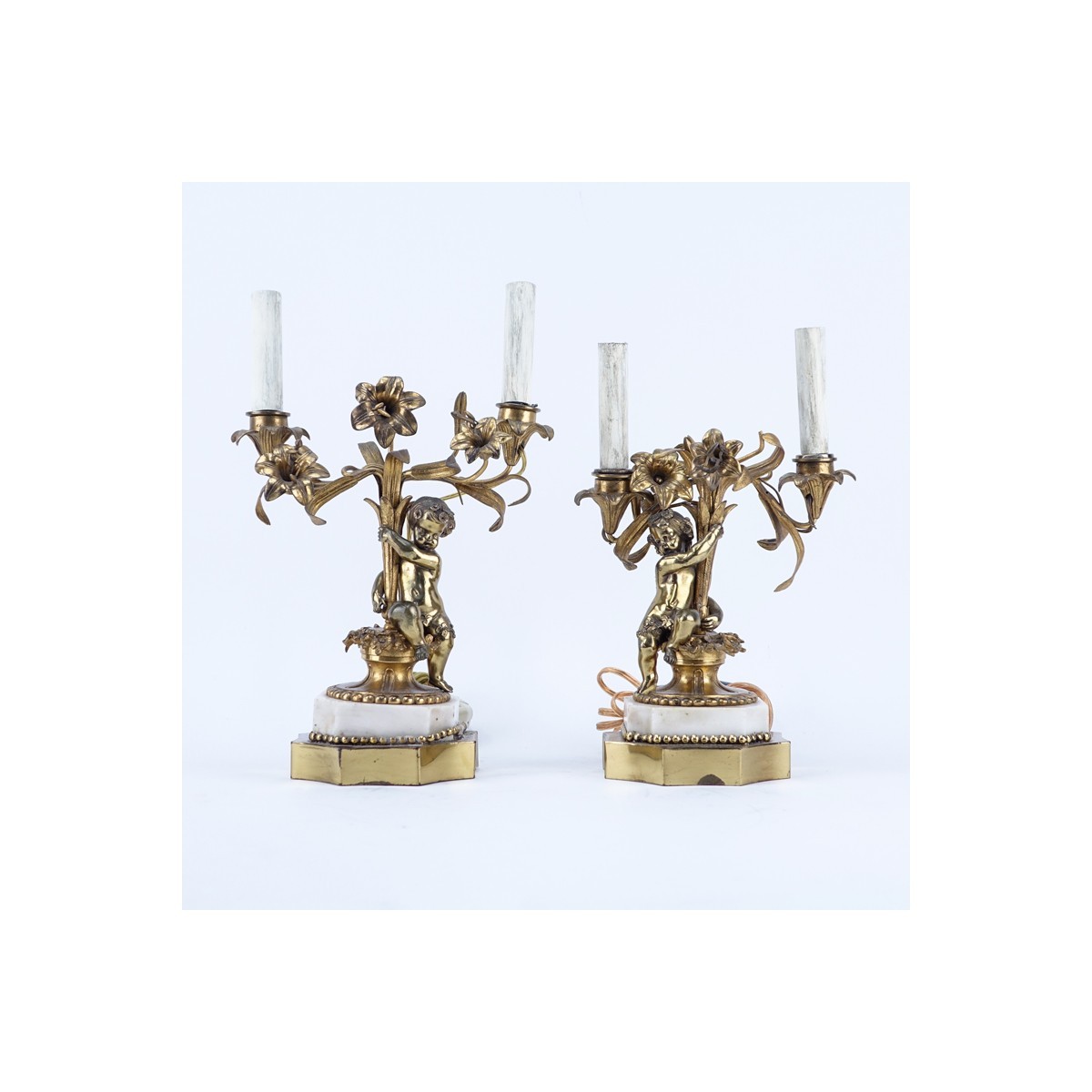 Pair of Gilt Brass Putti Two Light Electrified Candelabras. Each have been repaired, residue to surface, rubbing to gilt.