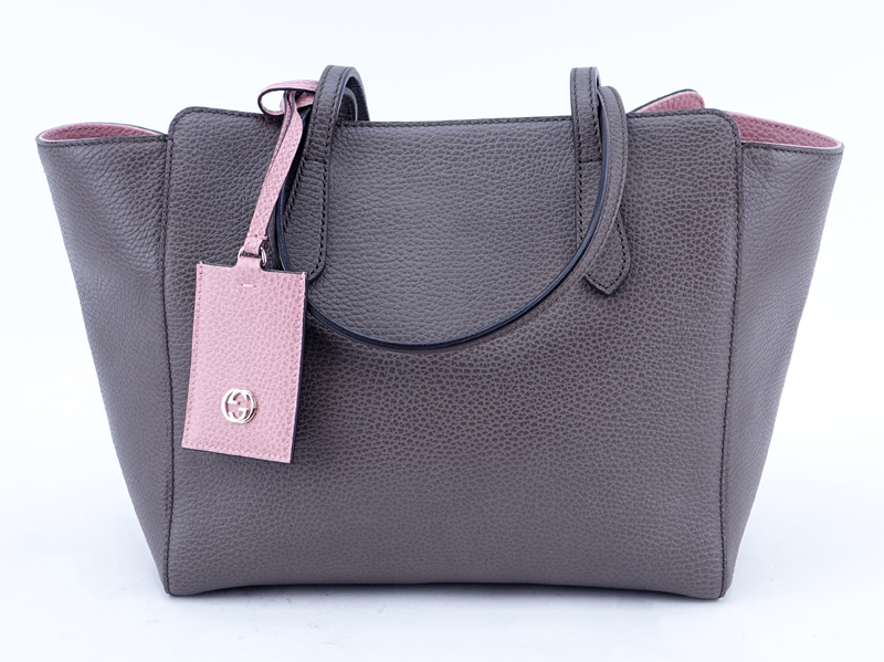 Gucci Taupe/Light Pink Grained Leather Swing PM Handbag. Gold tone hardware, interior of beige fabric with zippered and patch pockets.