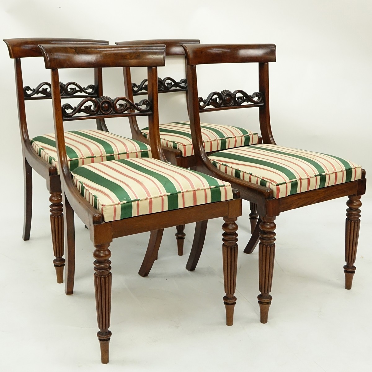 Set of Four (4) Antique English Regency style Carved Mahogany and Upholstered Side Chairs. Pierced splats and stands on tapered legs with molded front legs.