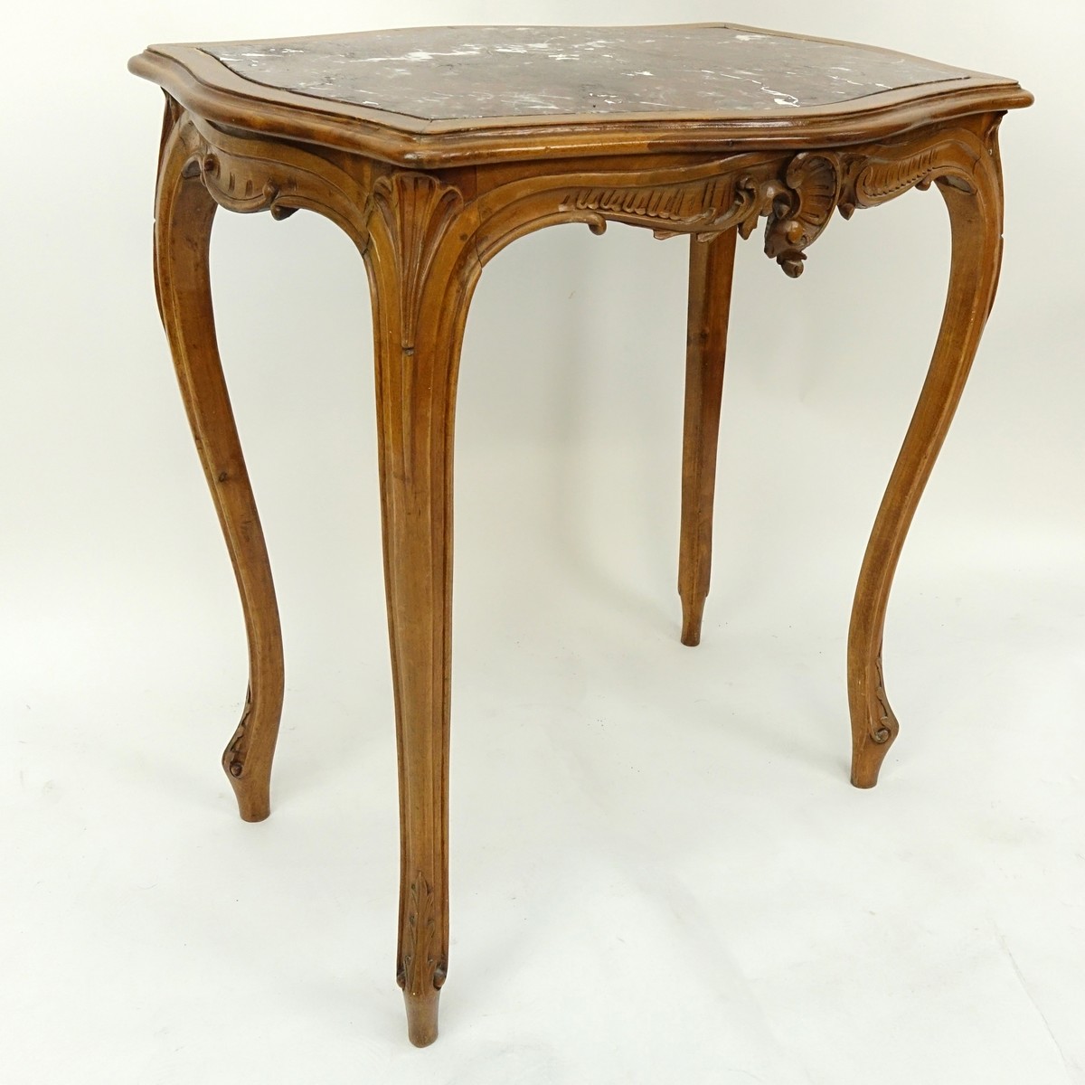 19/20th Century French Carved Wood Table with Marble Top. Carved apron with high cabriole legs.