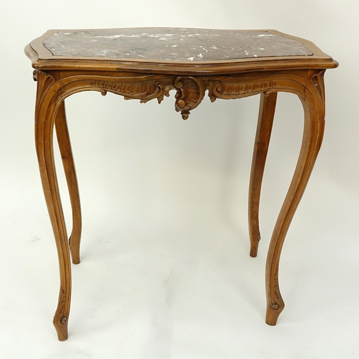 19/20th Century French Carved Wood Table with Marble Top. Carved apron with high cabriole legs.