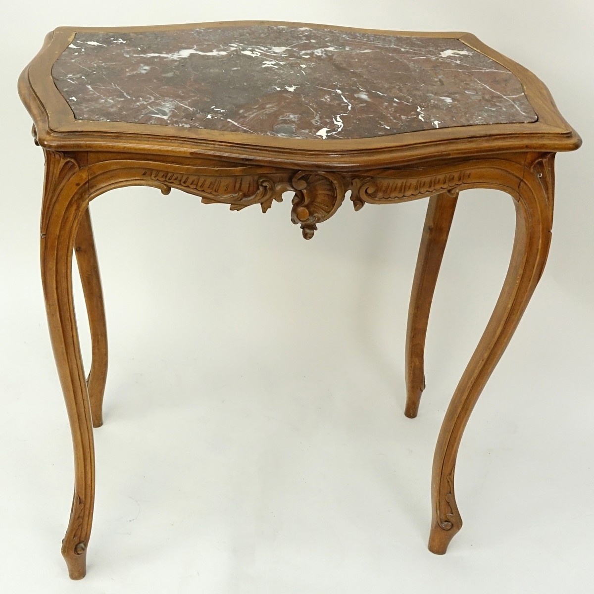 19/20th Century French Carved Wood Table with Marble Top. Carved apron with high cabriole legs.