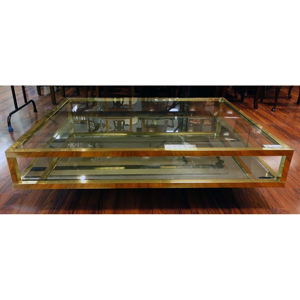 Mid Century Modern Mirrored and Glass Top Coffee Table. Scratches to brass, scratches to glass top, and mirror has a loss to corner.