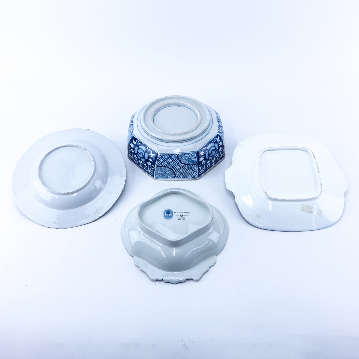 Four Pieces Blue & White Pottery Decorative Table Top Items. Includes a Mottahedeh Chinese motif dish, a flow blue platter, a Chinese bowl and an unsigned dish.