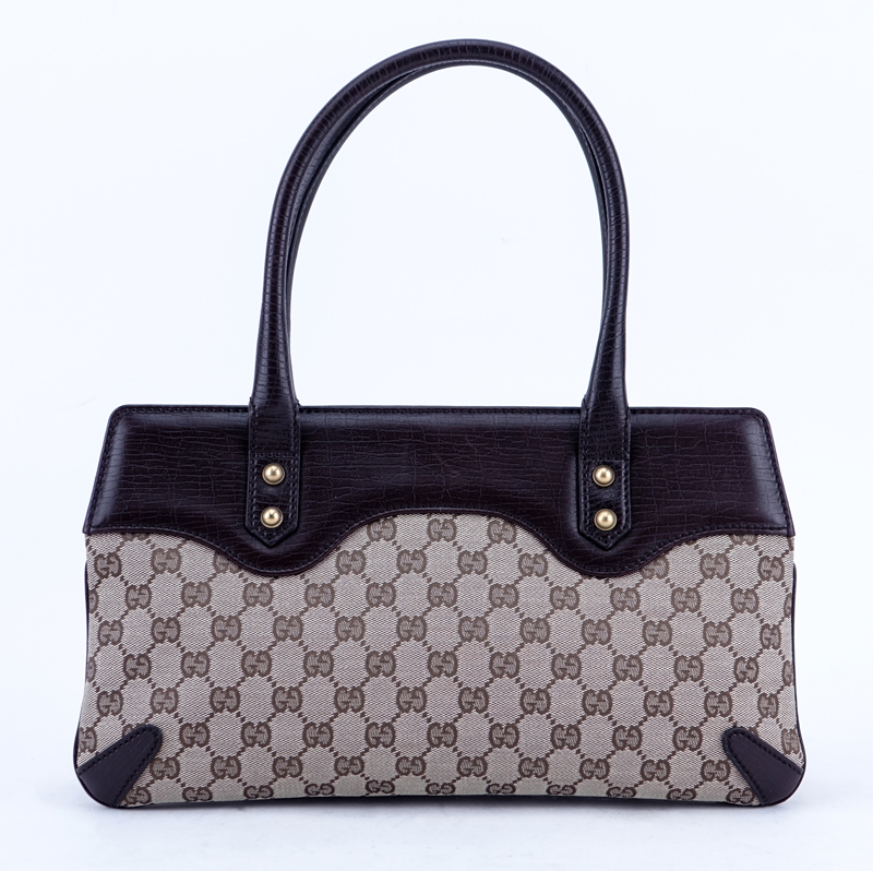 Gucci Beige/Brown Monogram Canvas And Leather Horsebit Tote Handbag. Brushed gold tone hardware, the interior of brown fabric with zippered pocket.