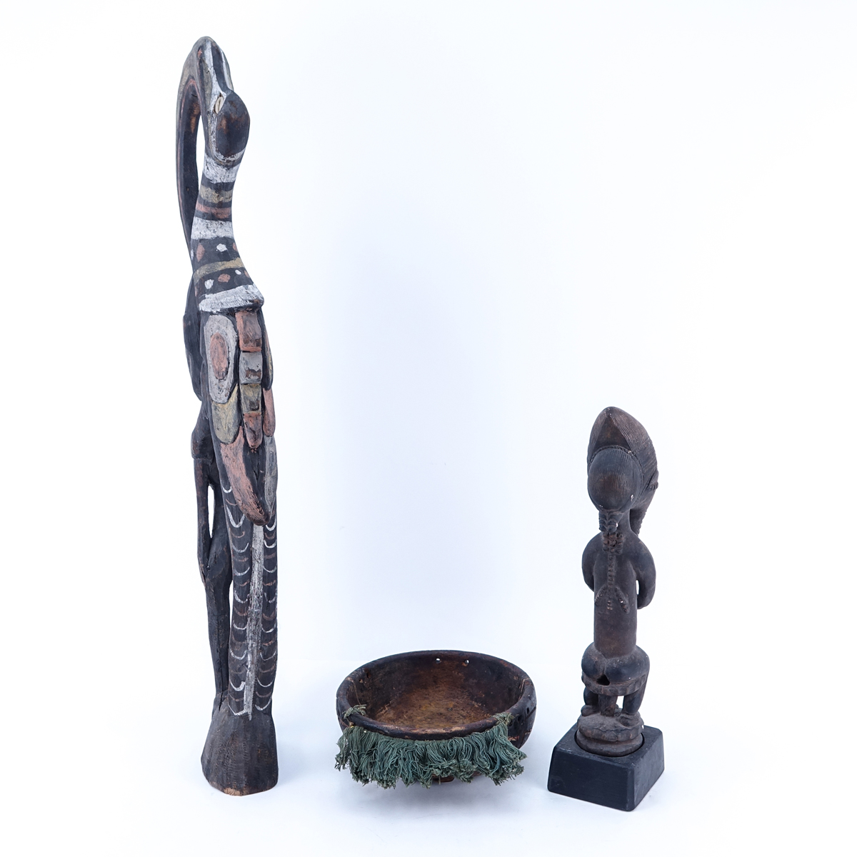Antique Tribal Grouping of Three (3): African Polychrome Hornbill Bird with Figure, African Round Carved Wood Mask, and Possibly Dayak Carved Seated Male Figure. All figures are in antique condition, splits and chips.