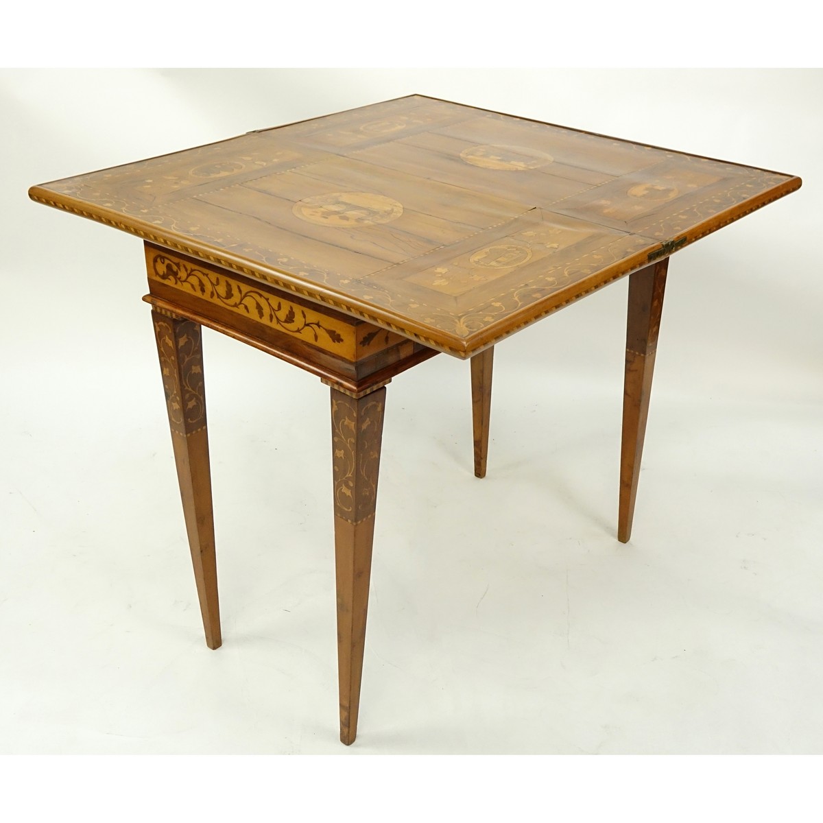 Antique Marquetry Inlaid Flip Top Game Table. Floral and scenic inlay work throughout the surface.