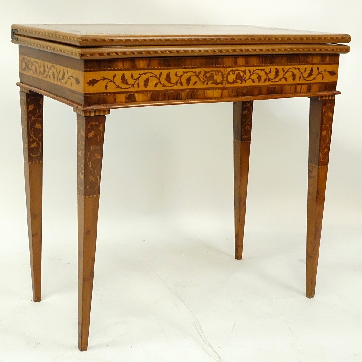 Antique Marquetry Inlaid Flip Top Game Table. Floral and scenic inlay work throughout the surface.