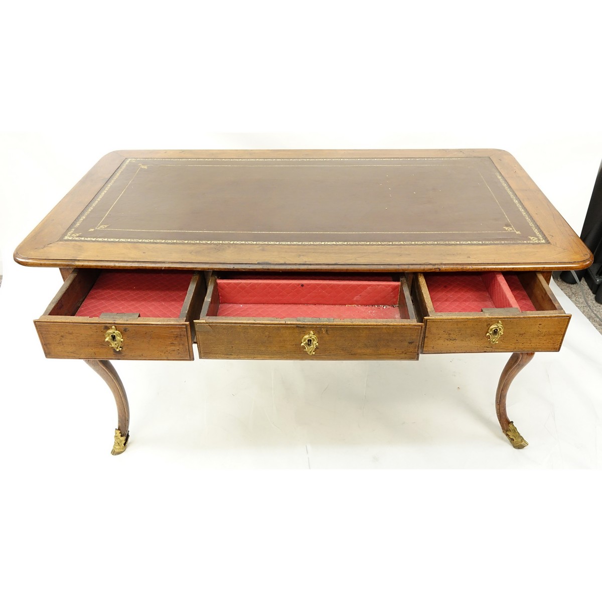 Large 19th Century French Walnut Writing Desk with Tooled Leather Top, Gilt Bronze Mounts. Large center drawer flanked by four fitted drawers, stands on tapering cabriole legs with hooves as feet.