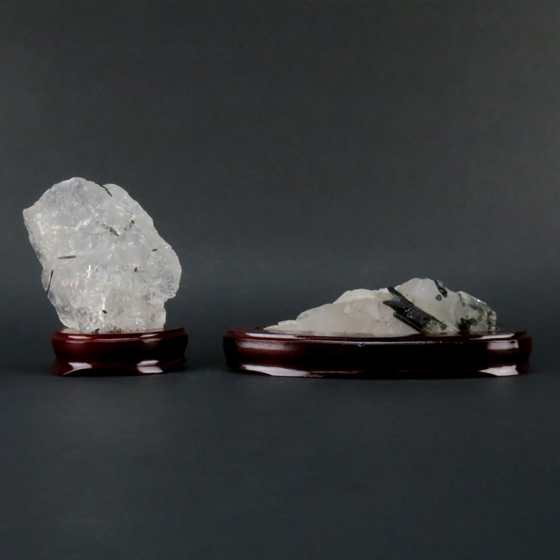 Two (2) Rock Crystal Mineral Specimen on Wooden Stands. Both are lightly smoky with black structures.