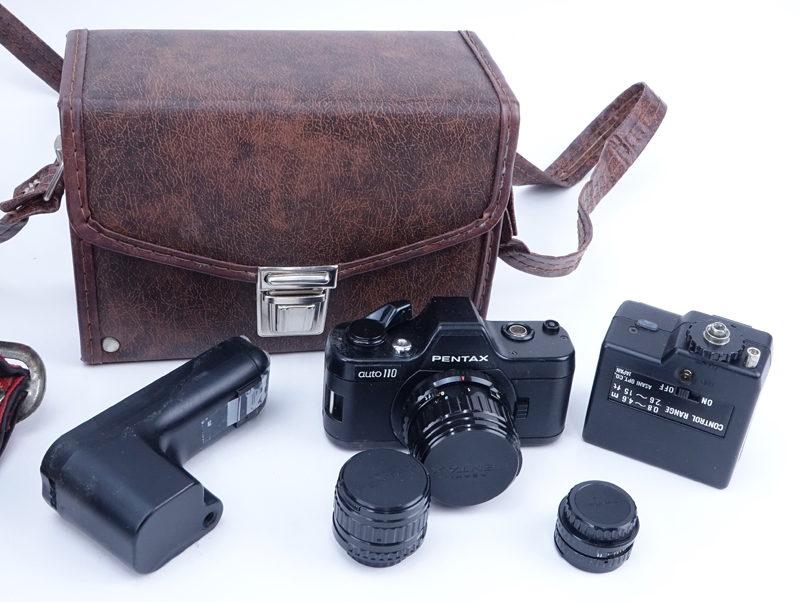 Grouping of Pentax K1000 and Pentax Auto 110 Film Cameras in Leather Traveling Cases. K1000 includes: Minolta auto 128.