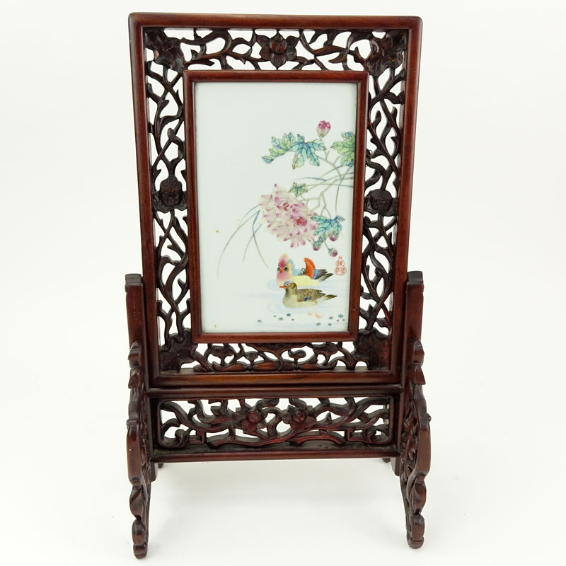 19/20th Century Chinese Hand Painted Porcelain Plaque Mounted in Carved Hardwood Frame As Table Screen. Decorated with colorful bird and flower motif.