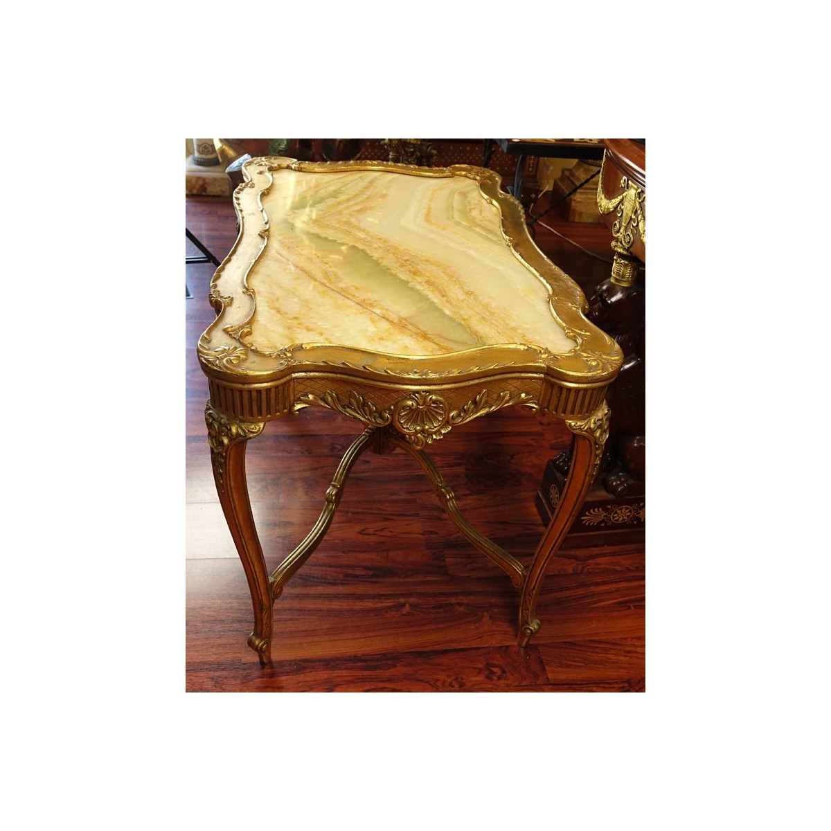 Early 20th Century Carved and Gilt Wood Center Table with Onyx Top. Decorated with carved scroll mo