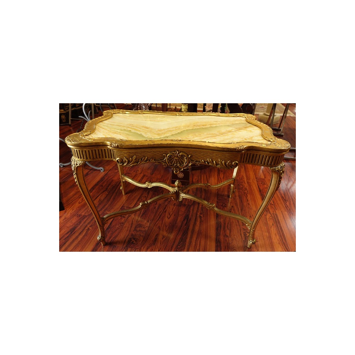 Early 20th Century Carved and Gilt Wood Center Table with Onyx Top. Decorated with carved scroll mo
